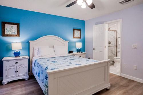 1 dormitorio con cama y pared azul en Bay View Villas #120 en Clearwater Beach