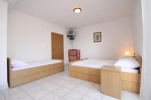 a hotel room with two beds and a chair at Studio Podaca 6902c in Podaca
