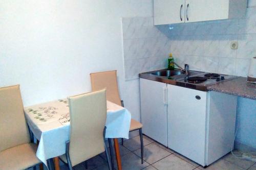 a small kitchen with a sink and a table and chairs at Studio Podaca 6902c in Podaca