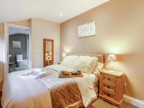 1 dormitorio con 1 cama y vestidor de madera con cartel en Caner Bach Lodge, en Bridgend