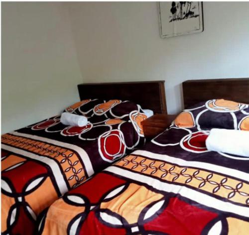 2 Betten mit bunten Bettdecken in einem Schlafzimmer in der Unterkunft Cabañas Campestre Sierra Viva in Zacatlán