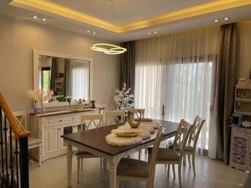 une salle à manger avec une table et des chaises ainsi qu'une cuisine dans l'établissement Marassi - El Alamein - Veneto Island - Ulta-Luxury Hotel-Style Villa, à El Alamein