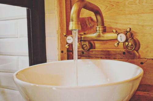 a sink with a faucet with water coming out of it at Pequeña cabaña mágica con chimenea interior in Arteaga