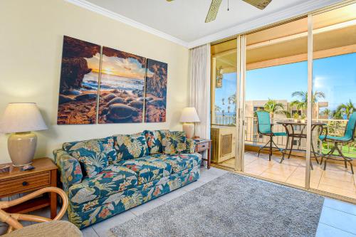 a living room with a couch and a view of the ocean at Menehune Shores 626 in Kihei