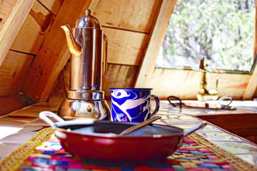 eine Schüssel auf einem Tisch mit einer Tasse und einem Entsafter in der Unterkunft Pequeña cabaña mágica con chimenea interior in Arteaga