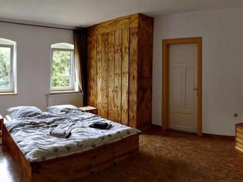 1 dormitorio con 1 cama grande y puerta de madera en Charming flat on two floors in a villa with a park in Großschirma en Großschirma