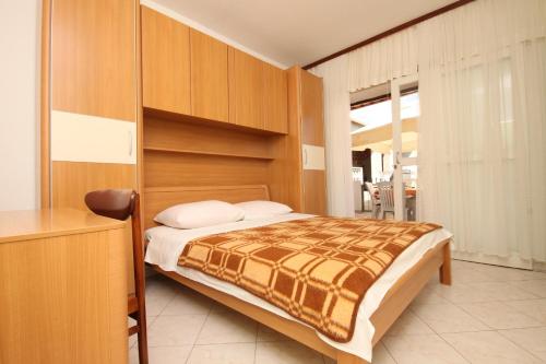 a bedroom with a bed and a dresser in it at Apartments by the sea Starigrad, Paklenica - 6586 in Starigrad