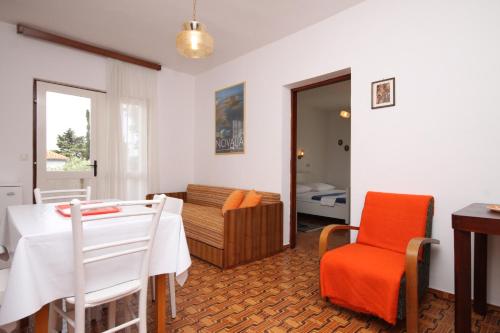 a living room with a white table and a chair at Apartments with a parking space Novalja, Pag - 6553 in Novalja