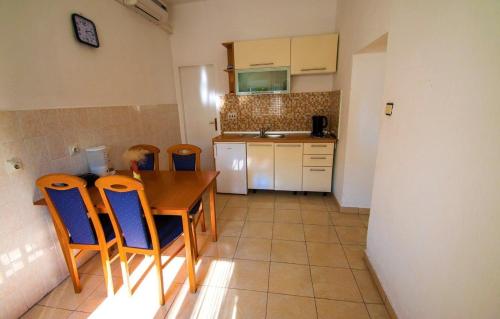 Una cocina con una mesa y sillas de madera. en Seaside holiday house Starigrad, Paklenica - 6633, en Starigrad-Paklenica