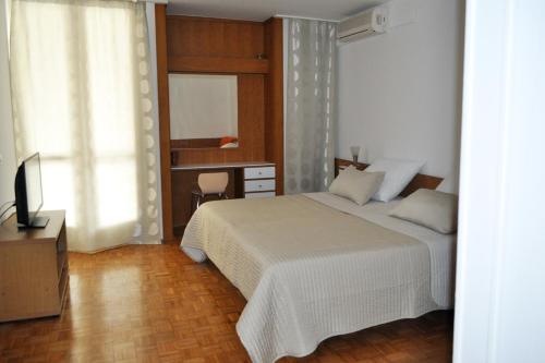 a bedroom with a bed and a desk and a window at Apartments by the sea Brela, Makarska - 6686 in Brela