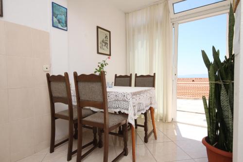 Un comedor con mesa y sillas y una ventana. en Apartments with a parking space Brela, Makarska - 6747, en Brela