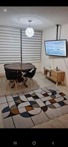 sala de estar con mesa y alfombra grande en Hermoso Departamento Centro de Iquique, en Iquique
