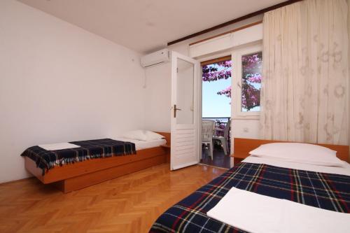 two beds in a room with a window and a bed sidx sidx sidx at Apartments and rooms with parking space Podgora, Makarska - 6790 in Podgora