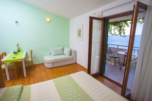 a bedroom with a bed and a room with a balcony at Apartments by the sea Podgora, Makarska - 6673 in Podgora