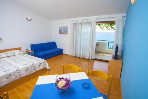 a living room with a bed and a table with a bowl on it at Apartments by the sea Podgora, Makarska - 6673 in Podgora