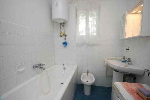 uma casa de banho com uma banheira, um WC e um lavatório. em Apartments with a parking space Biograd na Moru, Biograd - 6446 em Biograd na Moru