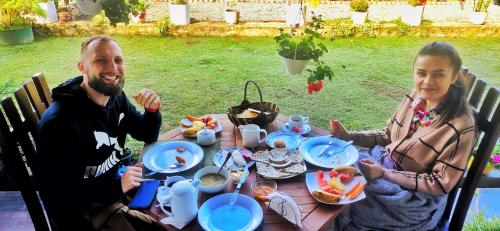 Ein Mann und eine Frau sitzen an einem Tisch mit Essen in der Unterkunft RC AWKWARD in Nuwara Eliya