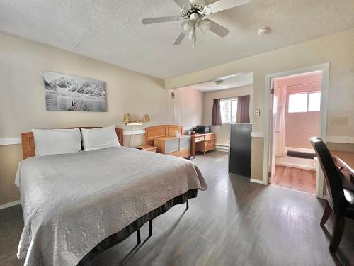 a bedroom with a bed and a living room at Rivermount Motel in Little Fort