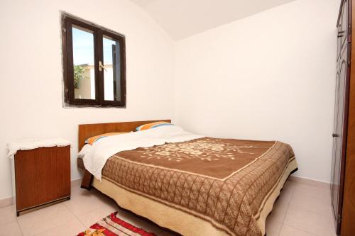 a bedroom with a bed and a mirror on the wall at Secluded fisherman's cottage Cove Statival, Kornati - 8164 in Pristanišće