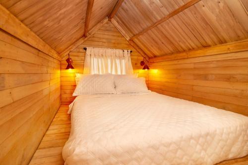 1 dormitorio con 1 cama en una cabaña de madera en Entremonte Cabañas, en La Vega