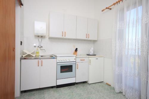 a white kitchen with white cabinets and a sink at Studio Kali 8202a in Kali