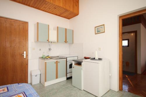 a kitchen with white cabinets and a white refrigerator at Apartments by the sea Kali, Ugljan - 8202 in Kali