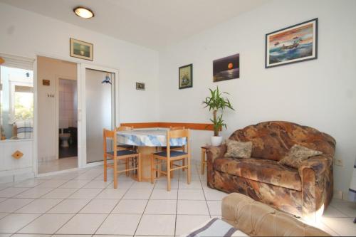 een woonkamer met een bank en een tafel bij Apartments by the sea Ugljan - 8423 in Ugljan