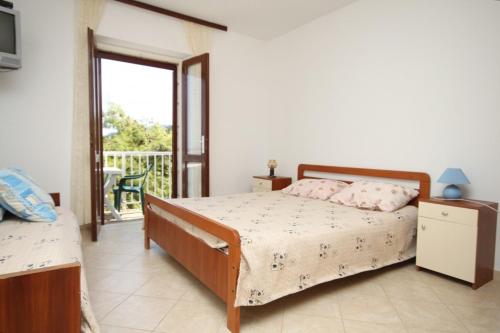 een slaapkamer met een bed en een balkon bij Apartments by the sea Zaklopatica, Lastovo - 8340 in Lastovo