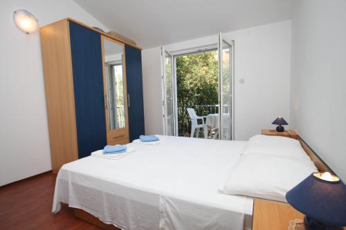 1 Schlafzimmer mit 2 weißen Betten und einem Fenster in der Unterkunft Apartment Pasadur 8337g in Ubli