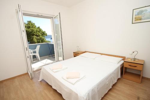 ein Schlafzimmer mit einem Bett und einem großen Fenster in der Unterkunft Apartments by the sea Pasadur, Lastovo - 8337 in Ubli