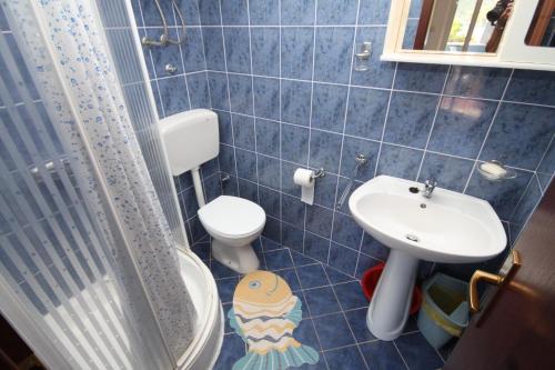 a blue tiled bathroom with a toilet and a sink at Apartments by the sea Pasadur, Lastovo - 8337 in Ubli