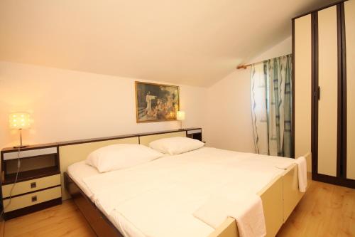 a bedroom with a large bed with white sheets at Apartments by the sea Zaklopatica, Lastovo - 8325 in Lastovo
