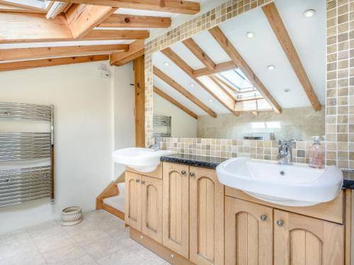 une salle de bain avec deux lavabos et une fenêtre dans l'établissement Pen Y Bryn Cottage, à Llandudno Junction