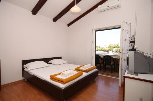 - une chambre avec un lit et une télévision dans l'établissement Apartments by the sea Bilo, Primosten - 8364, à Primošten