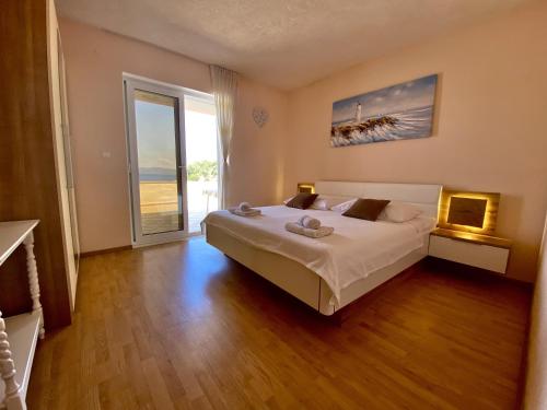 a bedroom with a large bed and a large window at Apartment Zaklopatica 8342b in Lastovo