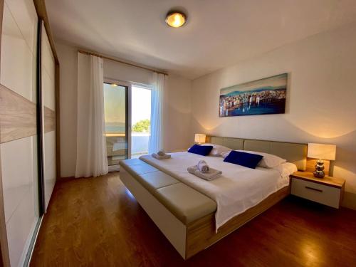 a bedroom with a large bed and a large window at Apartments by the sea Zaklopatica, Lastovo - 8342 in Lastovo