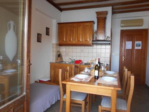 eine Küche mit einem Holztisch mit Stühlen und einem Bett in der Unterkunft Apartments by the sea Zaklopatica, Lastovo - 8346 in Lastovo