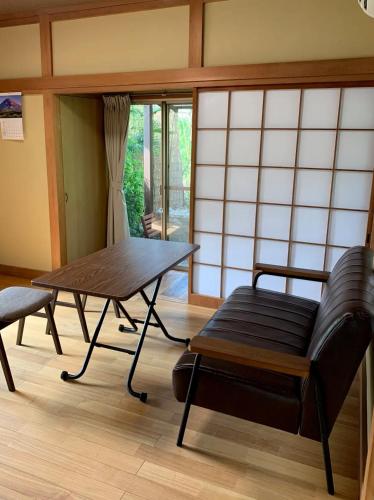 a living room with a table and a couch and a table at HOSHIYAMA B extra for pets - Vacation STAY 13934v in Fujinomiya