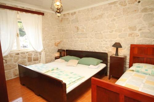 a bedroom with two beds and a stone wall at Seaside holiday house Lucica, Lastovo - 8348 in Lastovo