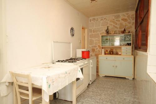 a kitchen with a table and a stove top oven at Seaside holiday house Lucica, Lastovo - 8348 in Lastovo