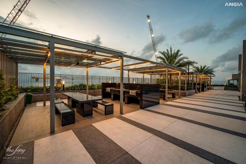 a patio with tables and benches on a building at The Song Luxury Condotel Vung Tau - Căn hộ cao cấp Luca's House in Vung Tau
