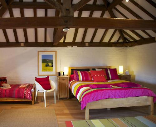 um quarto com uma cama grande e uma cadeira em B&B at The Old Mill em Devizes