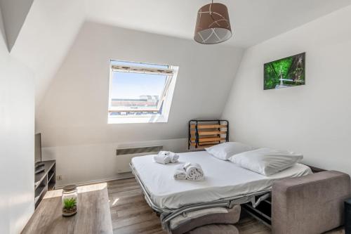 une petite chambre avec un lit et une fenêtre dans l'établissement Appartement Risco - Welkeys, à Villers-sur-Mer