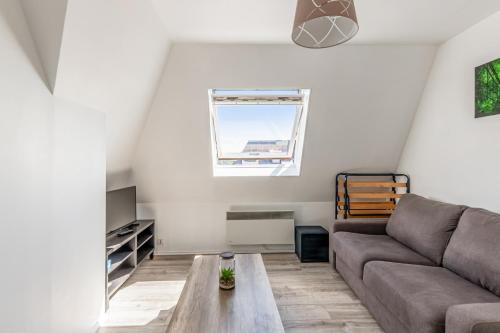 un salon avec un canapé et une table dans l'établissement Appartement Risco - Welkeys, à Villers-sur-Mer