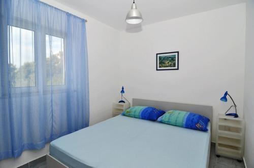 a bedroom with a bed with blue curtains and a window at Studio Pasadur 8351a in Ubli