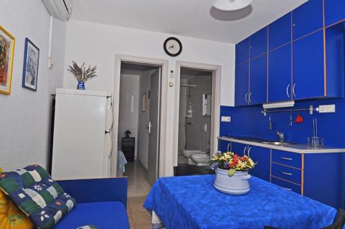 eine Küche mit blauen Schränken und einem Tisch mit Blumen darauf in der Unterkunft Apartments by the sea Pasadur, Lastovo - 8351 in Ubli