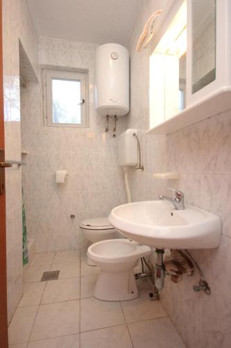 a white bathroom with a toilet and a sink at Apartment Poljana 8473c in Poljana