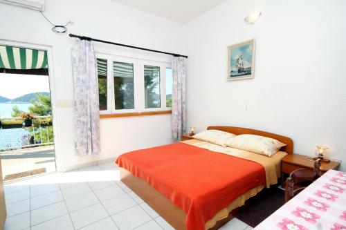 a bedroom with a bed and a large window at Apartments by the sea Ubli, Lastovo - 8354 in Ubli