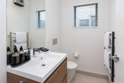 Baño blanco con lavabo y aseo en URBAN RETREAT, en Christchurch