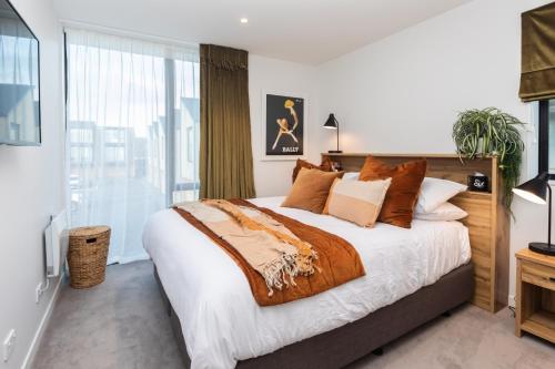 a bedroom with a large bed and a large window at URBAN RETREAT luxury city stay in Christchurch